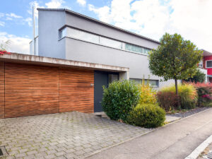 Hausansicht mit Garage und Stellplatz davor