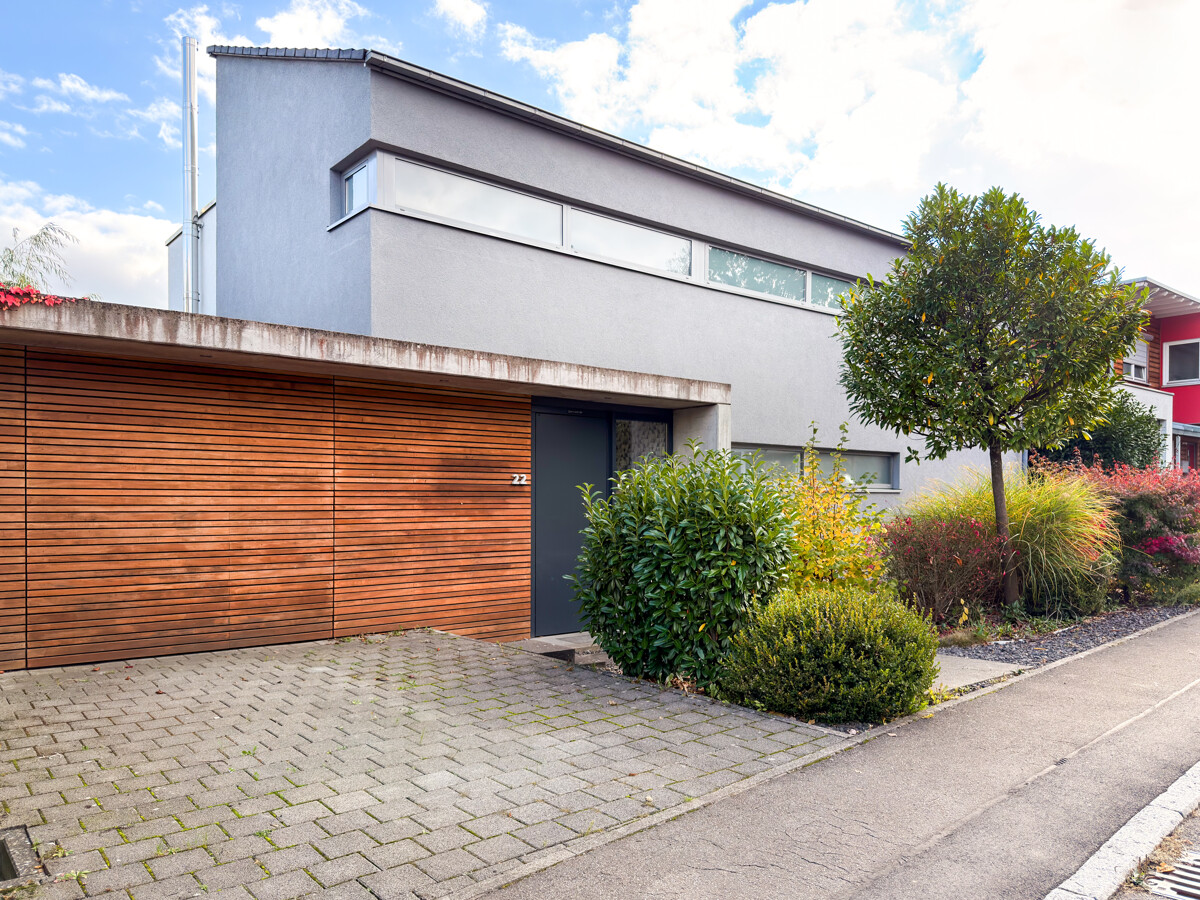 Hausansicht mit Garage und Stellplatz davor